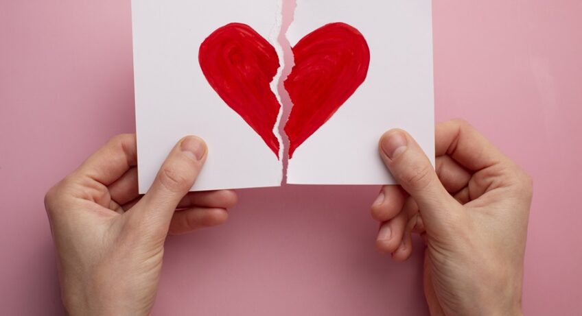 mani che tengono 1 foglio strappato con disegno cuore